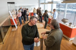 Mehrere Personen stehen vor den Vitrinen der Ausstellung