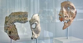 Zwei Gesichtsmasken hinter einer Glasvitrine