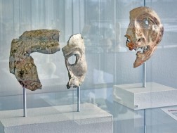 Zwei Gesichtsmasken hinter einer Glasvitrine