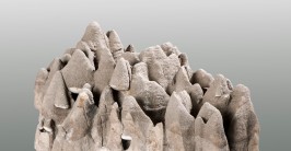 Ein grauer Stein mit mehreren kleinen Kegeln, deren abgerundete Spitzen nach oben gerichtet sind