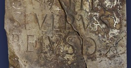 Gebrochener, alter Stein mit eingemeißelter Schrift