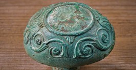 Ein mit Rankenmustern verzierter Türknauf aus grünlich angelaufener Bronze