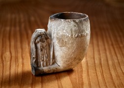 Vorderseite des 4,5 cm hohen Pfeifenkopfes mit Inschriftenrest und unvollst&auml;ndiger Figur des Hl. Cornelius. Foto: J&uuml;rgen Vogel/LVR-Landesmuseum Bonn