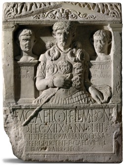 Grabstein mit drei Köpfen und lateinischer Inschrift