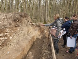 Archäologin erklärt den Aufbau des ausgegrabenen Walls