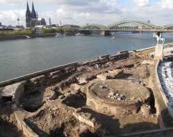 Ausgrabungen am Rheinufer in Köln-Deutz, im Hintergrund Dom und Eisenbahnbrücke.
