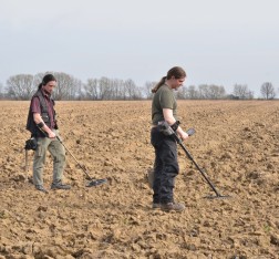 Zwei Männer mit Metalldetektoren auf einem Acker
