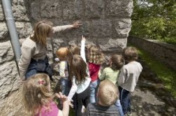 Schüler suchen nach Fossilien in der Kalksteinmauer der Kirche in Frohngau. (Foto: Michael Thuns, LVR-ABR)